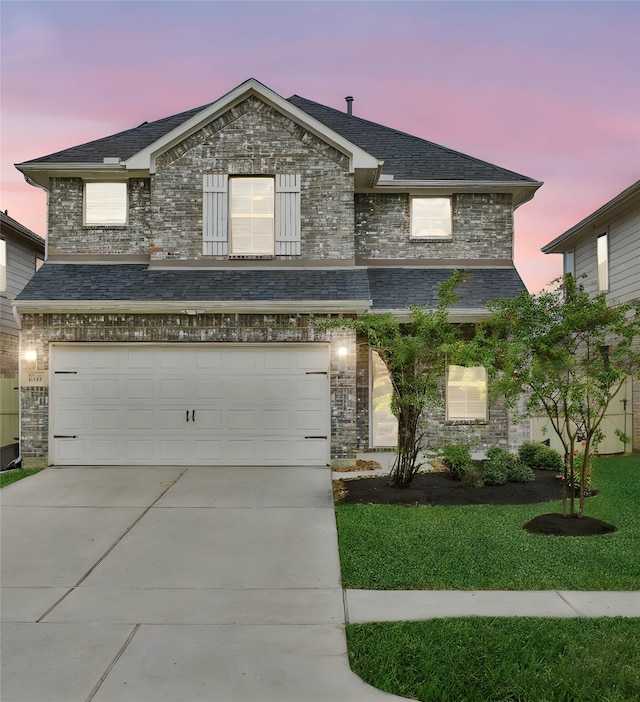 view of front of property featuring a lawn and a garage