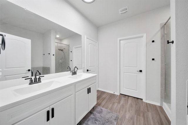 bathroom featuring a shower with door, vanity, and hardwood / wood-style flooring