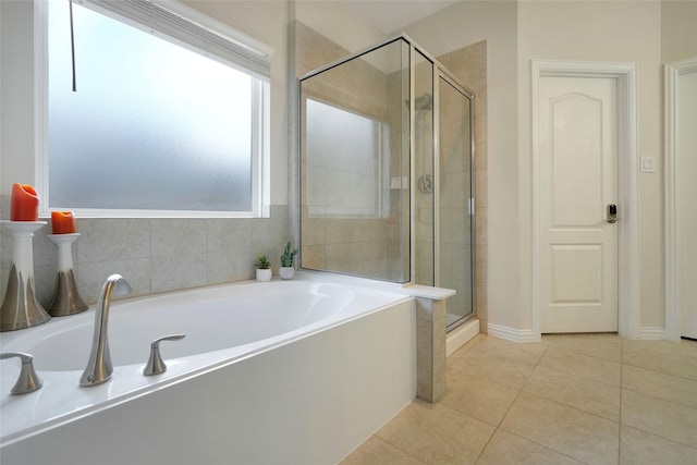 bathroom featuring plus walk in shower, tile patterned flooring, and plenty of natural light