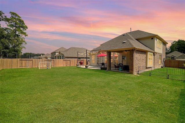 yard at dusk featuring a patio