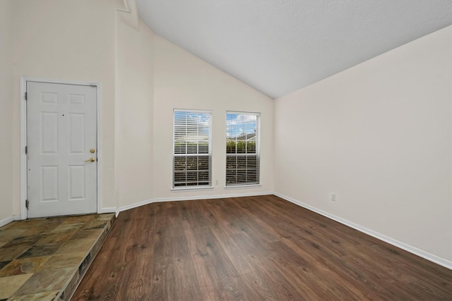 spare room with dark hardwood / wood-style floors and vaulted ceiling