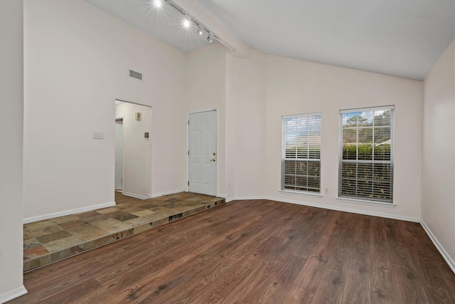 interior space with dark hardwood / wood-style floors, lofted ceiling, and rail lighting