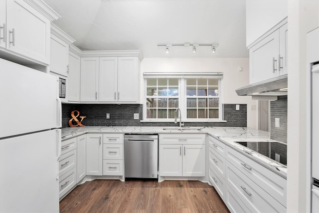 kitchen with white cabinets, sink, tasteful backsplash, light stone counters, and stainless steel appliances