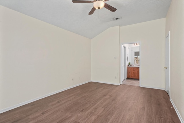 empty room featuring light wood-type flooring, vaulted ceiling, and ceiling fan