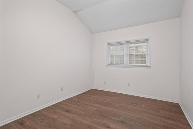 unfurnished room with dark hardwood / wood-style floors and vaulted ceiling