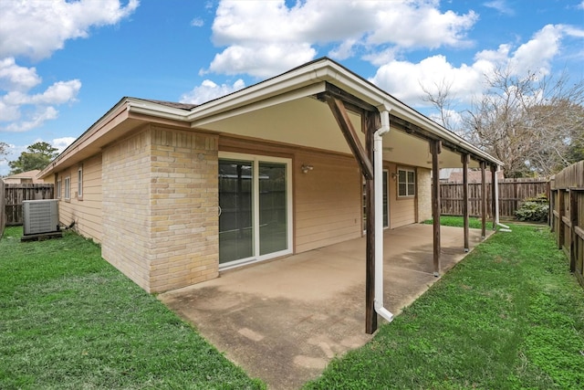 back of house with a yard, cooling unit, and a patio