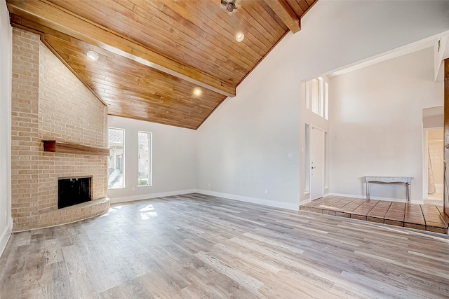 unfurnished living room with a fireplace, high vaulted ceiling, light hardwood / wood-style flooring, and wood ceiling