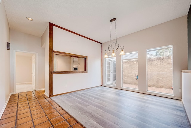 unfurnished dining area featuring high vaulted ceiling and a notable chandelier