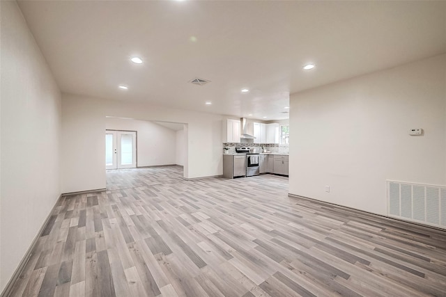 unfurnished living room with french doors and light wood-type flooring