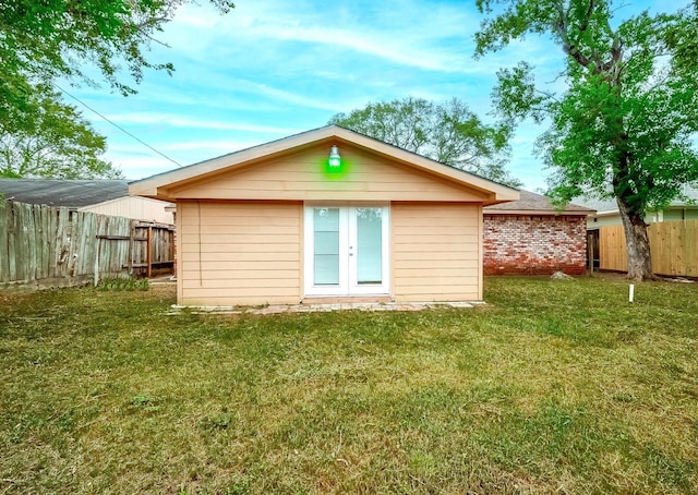 back of property featuring an outbuilding and a yard