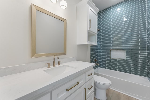 full bathroom featuring vanity, hardwood / wood-style floors, toilet, and tiled shower / bath