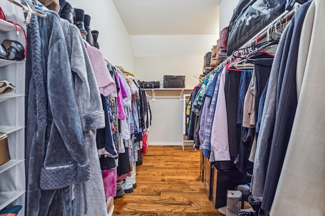 walk in closet featuring hardwood / wood-style floors and lofted ceiling