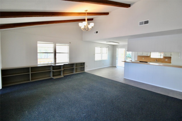 unfurnished living room featuring beamed ceiling, carpet flooring, high vaulted ceiling, and a chandelier