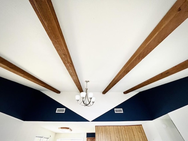 room details featuring beam ceiling and a notable chandelier