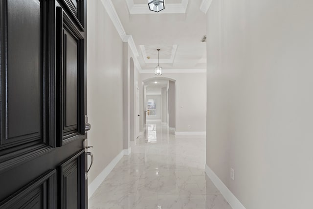 corridor with a tray ceiling and ornamental molding