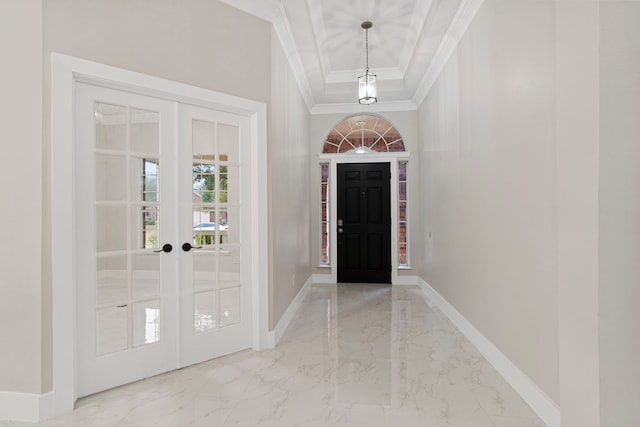 foyer with ornamental molding, french doors, and a tray ceiling