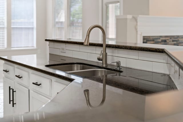 kitchen featuring white cabinetry and sink