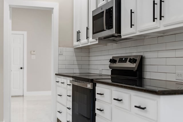 kitchen with white cabinets, backsplash, and appliances with stainless steel finishes