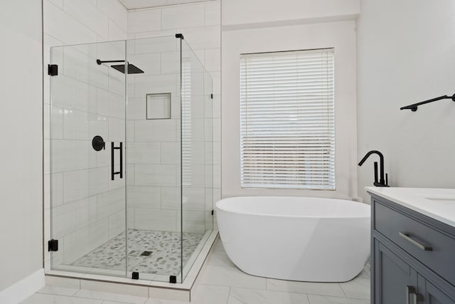 bathroom with vanity and shower with separate bathtub