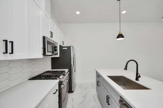 kitchen featuring white cabinets, stainless steel appliances, backsplash, and pendant lighting