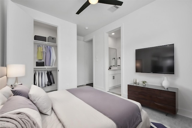 bedroom with ensuite bath, a closet, ceiling fan, and light colored carpet