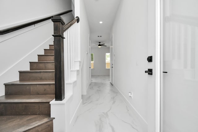 stairs featuring ceiling fan