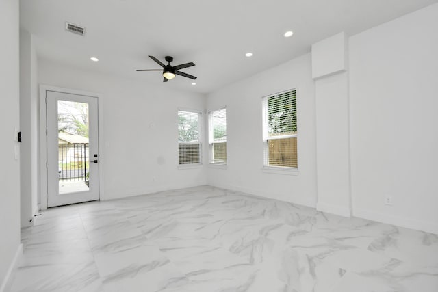 empty room featuring ceiling fan and plenty of natural light