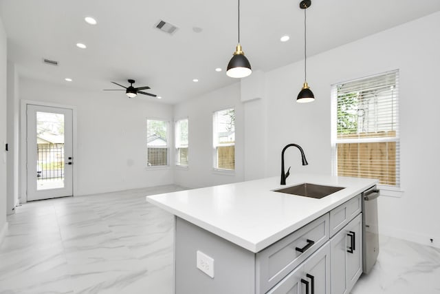 kitchen with sink, decorative light fixtures, dishwasher, ceiling fan, and an island with sink