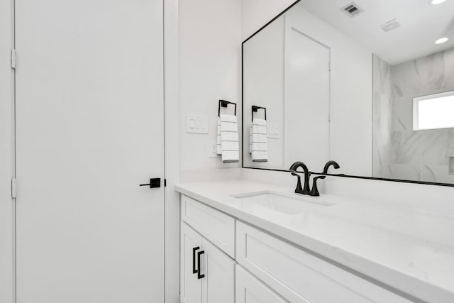 bathroom featuring walk in shower and vanity