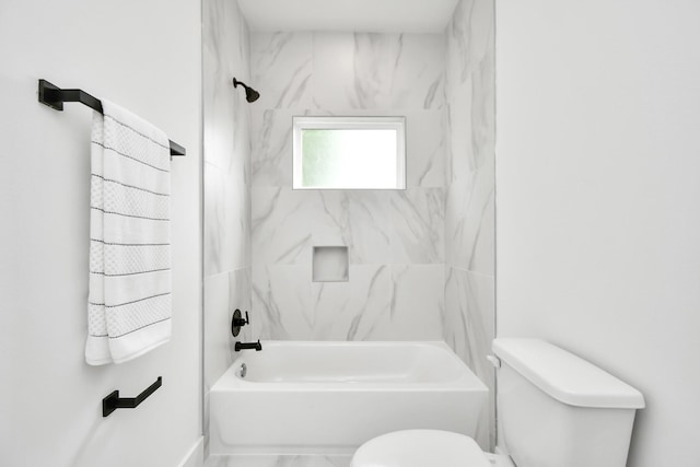 bathroom with tiled shower / bath combo and toilet