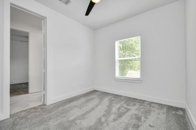 carpeted spare room with ceiling fan