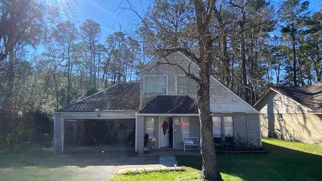 view of front of home with covered porch, a front yard, and a garage