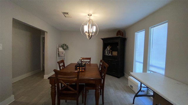 dining space with wood-type flooring and a chandelier