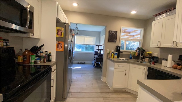 kitchen with white cabinets, black appliances, and sink