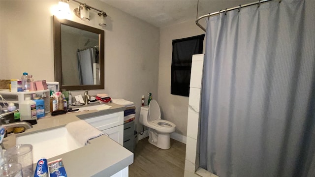 bathroom with walk in shower, toilet, vanity, and hardwood / wood-style flooring