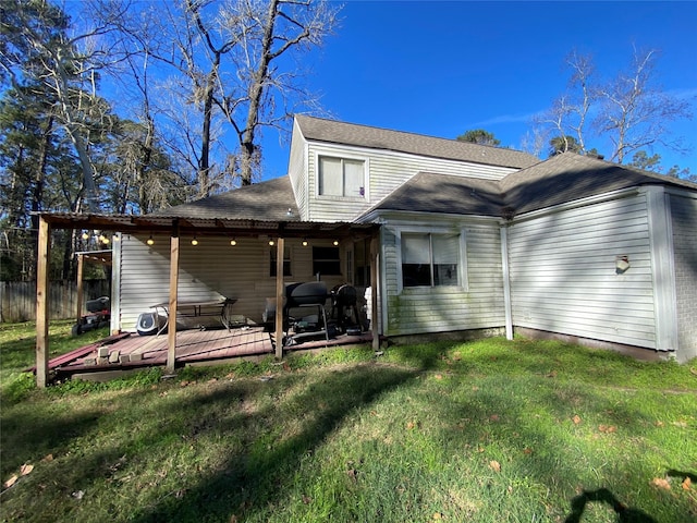 rear view of property featuring a yard and a wooden deck