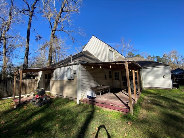 back of property featuring a deck and a yard