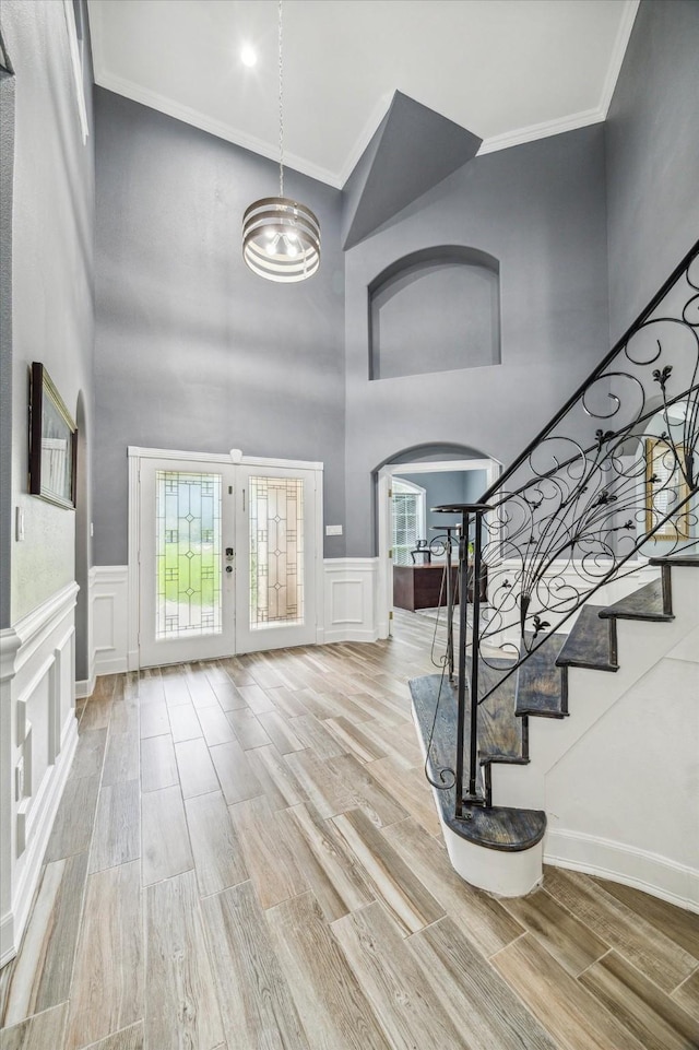 foyer entrance featuring ornamental molding, a chandelier, and a high ceiling