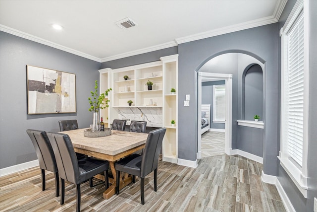 dining room with light hardwood / wood-style floors and ornamental molding