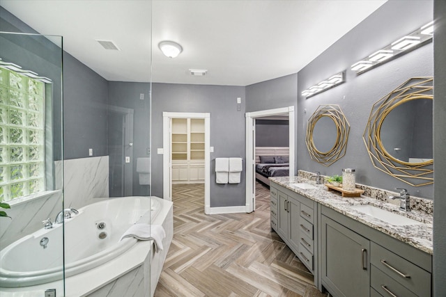 bathroom with a washtub, parquet flooring, and vanity