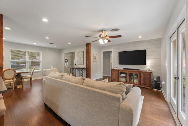 living room featuring ceiling fan and dark hardwood / wood-style floors