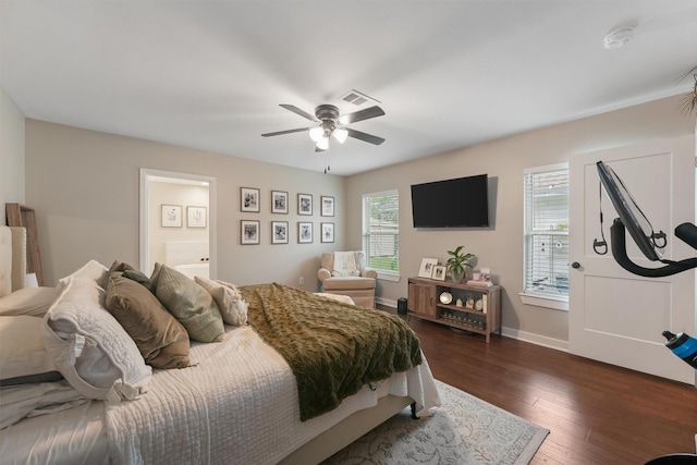 bedroom featuring ensuite bathroom, ceiling fan, dark hardwood / wood-style flooring, and multiple windows