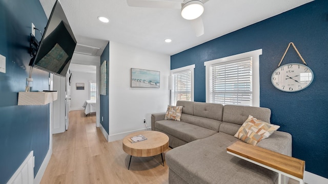 living room with light wood-type flooring and ceiling fan