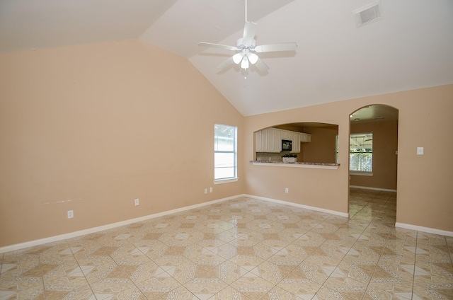 unfurnished living room with lofted ceiling, light tile patterned flooring, ceiling fan, and a wealth of natural light