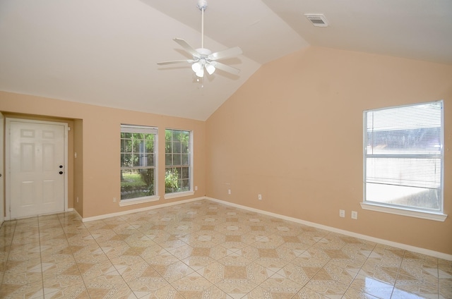 tiled spare room with ceiling fan, vaulted ceiling, and plenty of natural light