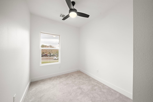 empty room with ceiling fan and light carpet