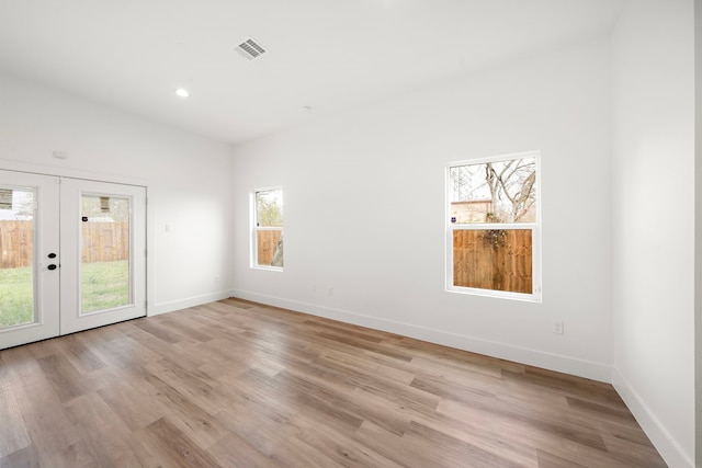 unfurnished room with french doors and light hardwood / wood-style floors