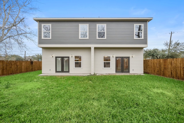 rear view of house with a lawn and french doors