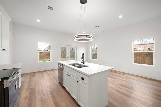 kitchen with sink, stainless steel appliances, white cabinets, and a kitchen island with sink