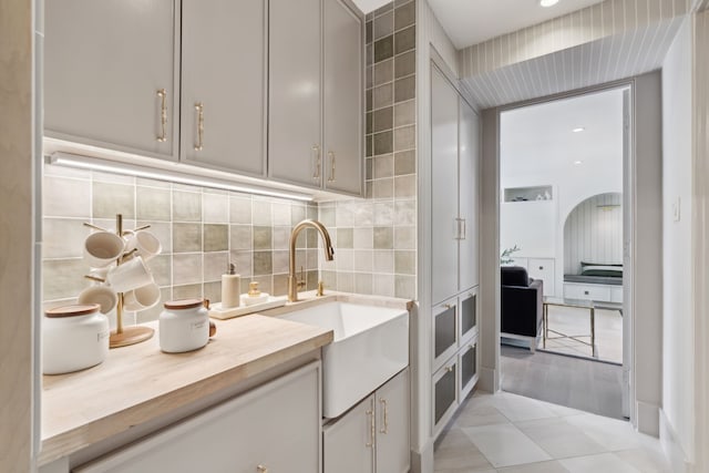 kitchen with sink, backsplash, and light tile patterned floors